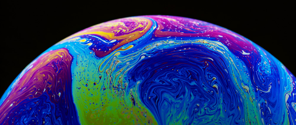 Science of refraction and reflection is demonstrated by colors in the surface film of a soap bubble.